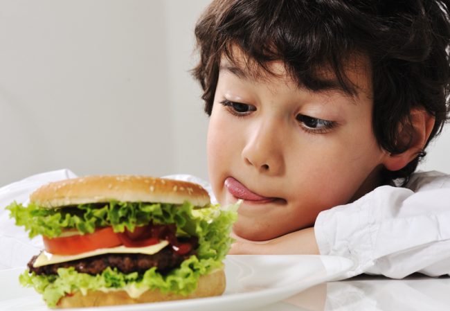 Boy on temptation with burger Boy on temptation with burger
